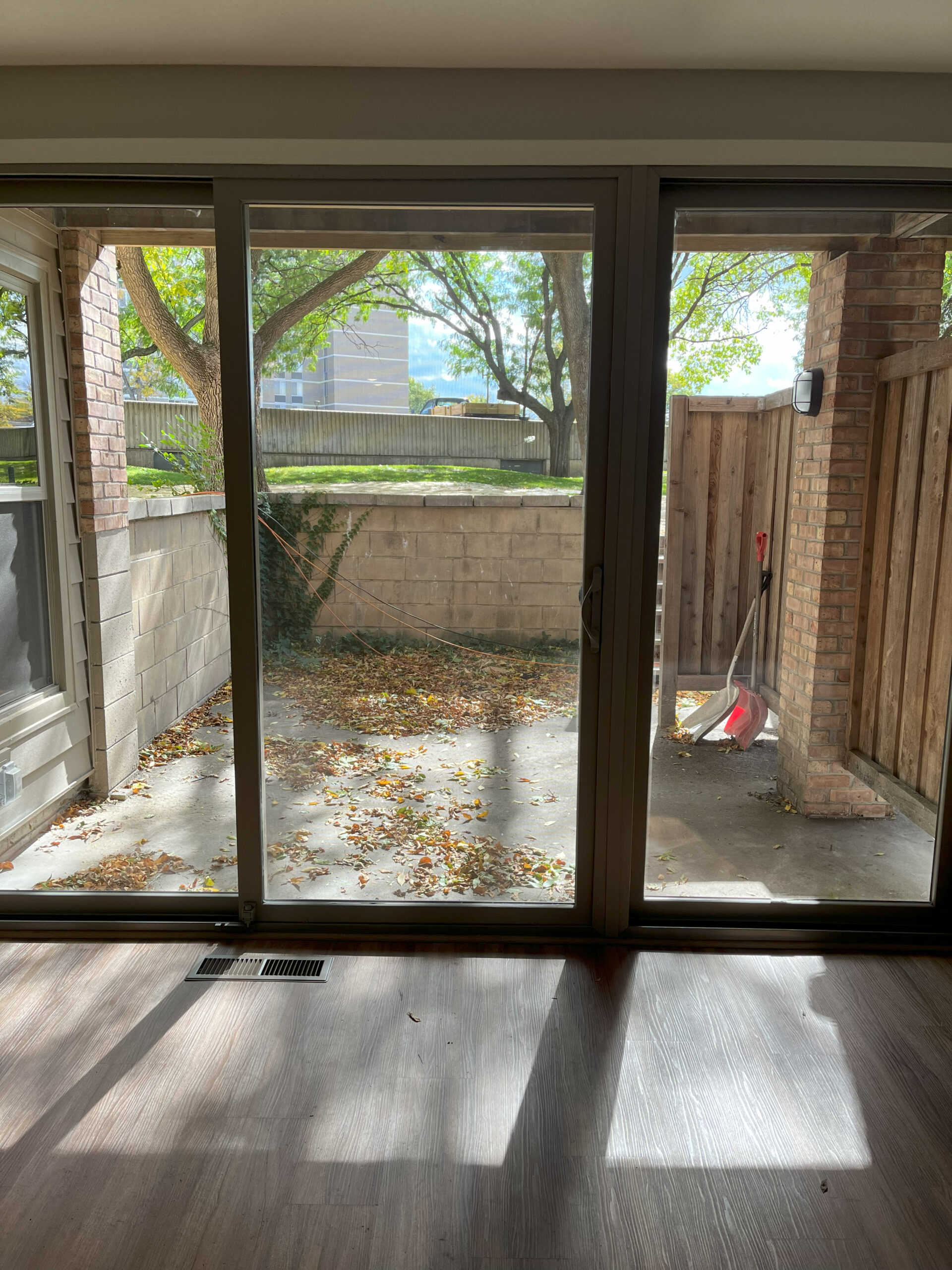 A condo living room looking through sliding glass doors to the patio