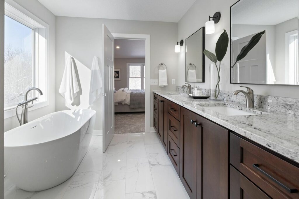 a bathroom with a tub and double sink