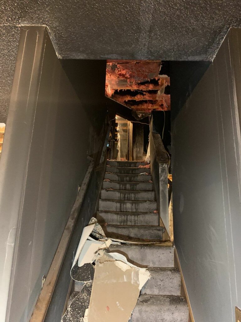 a staircase with fire damage and debris on the stairs