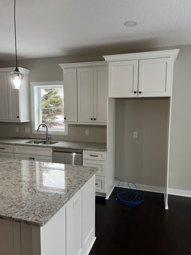 a kitchen with white cabinets and a sink