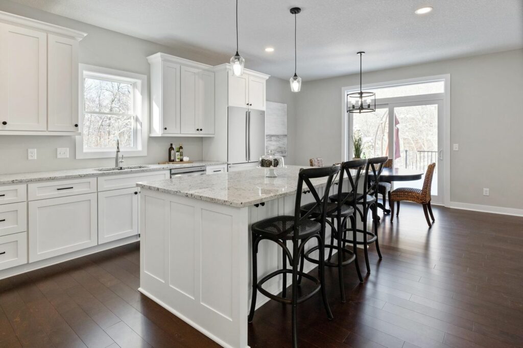 a kitchen with a dining table and chairs and an island with stools