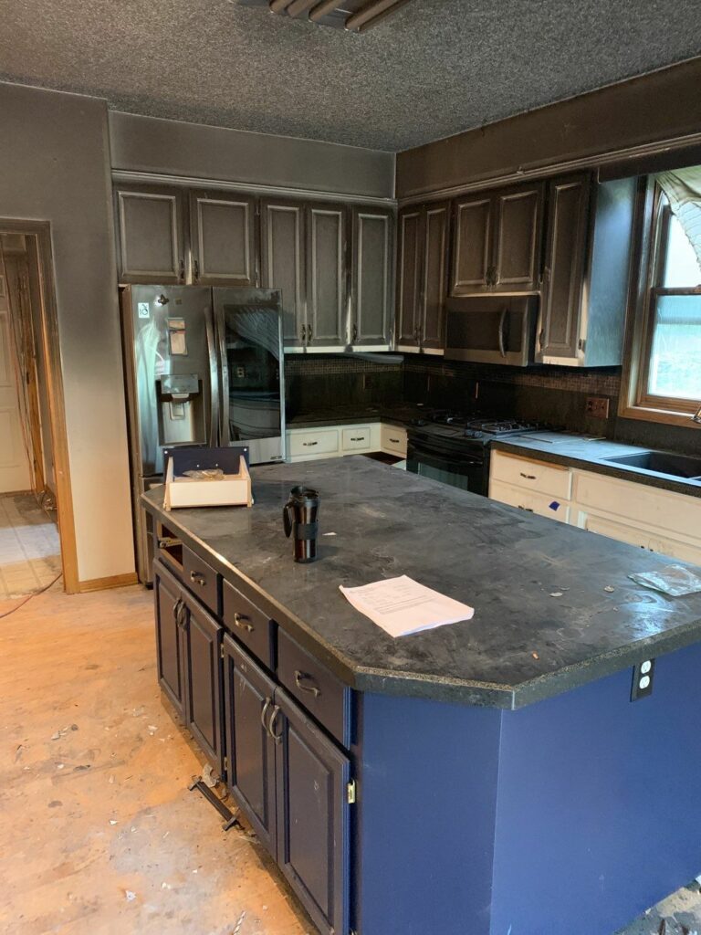 a kitchen with fire damage and soot stains