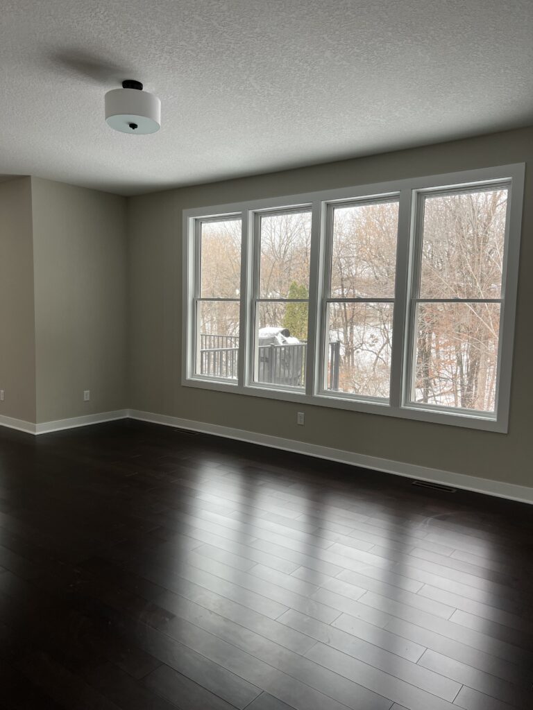 a room with windows and hardwood floors