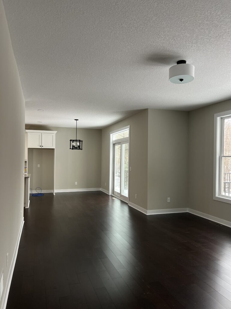 Living room with dark hardwood floors, white trim, and neutral wall colors