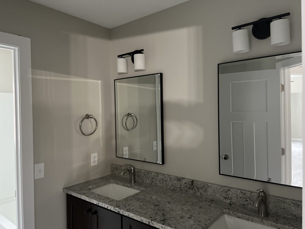 a bathroom with a double sink and mirrors