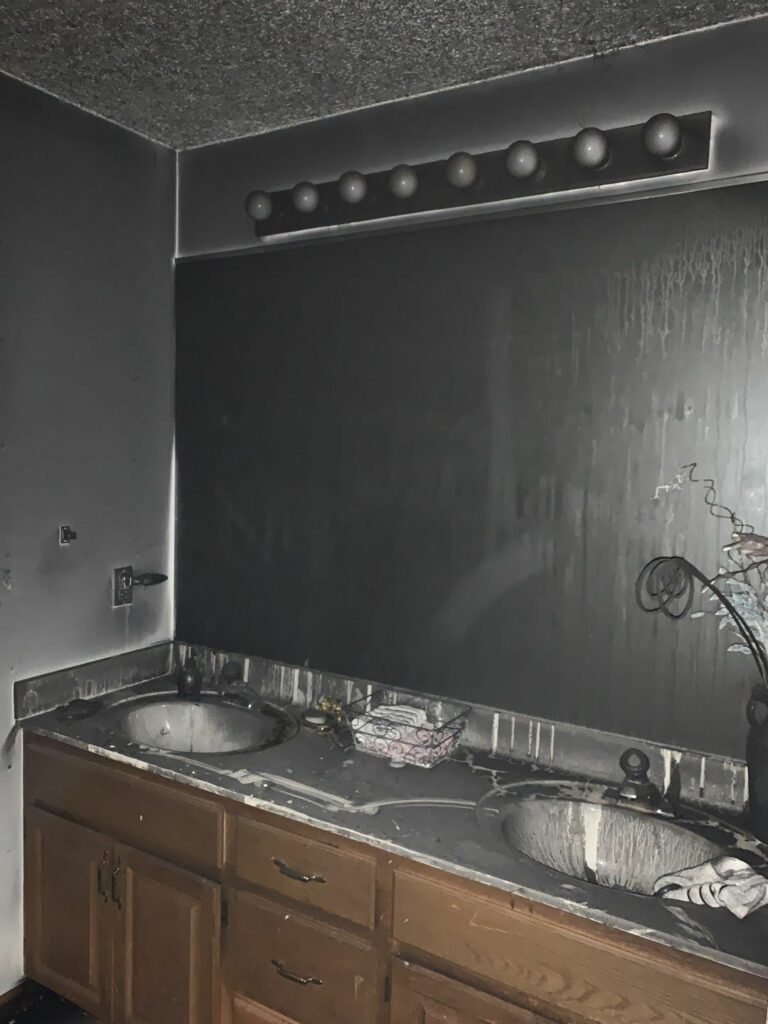 a bathroom with a soot covered mirror and sinks