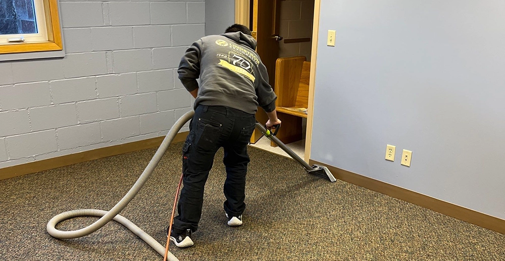 Employee vacuuming up water